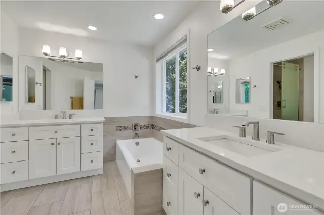 Luxurious primary bath with dual vanities, soaking tub, and separate shower.