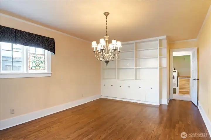 Dining room or primary en-suite with full bathroom on backside of wall with the built-in cabinets. Laundry right outside bedroom door.