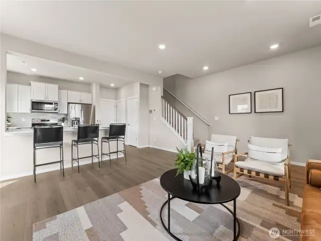 Wide view captures breakfast-bar seating, durable LVP flooring and stair access to private bedroom retreat upstairs. Pictures are for representational purposes only, colors and features may vary.