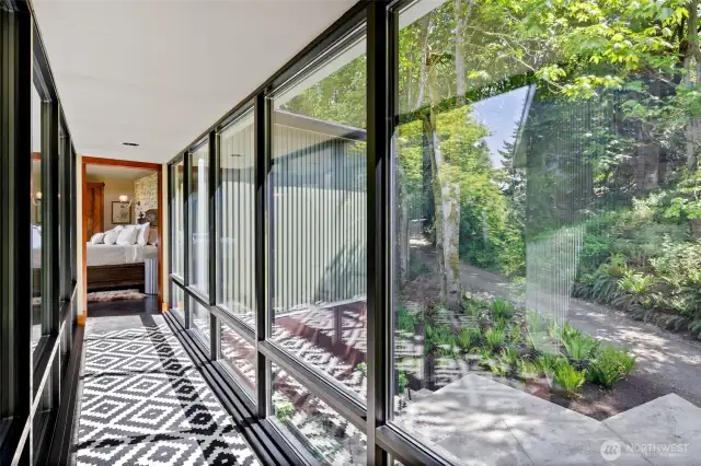 Skybridge walkway to primary bedroom suite- windows on both sides. An elegant and striking design feature.