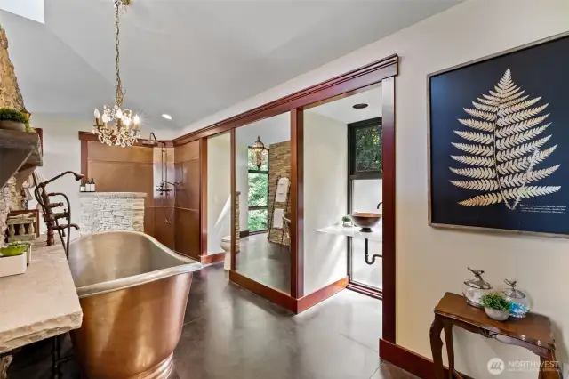 Beautiful primary bathroom area with huge copper soaking tub, vanity and shower. Beautiful finishes and striking fixtures.