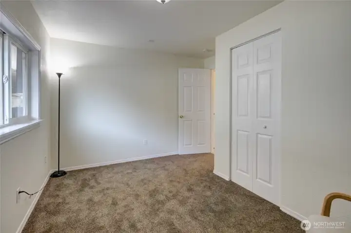 another  view of #3 bedroom/office space. with a Door to the side of the home and  a closet space.