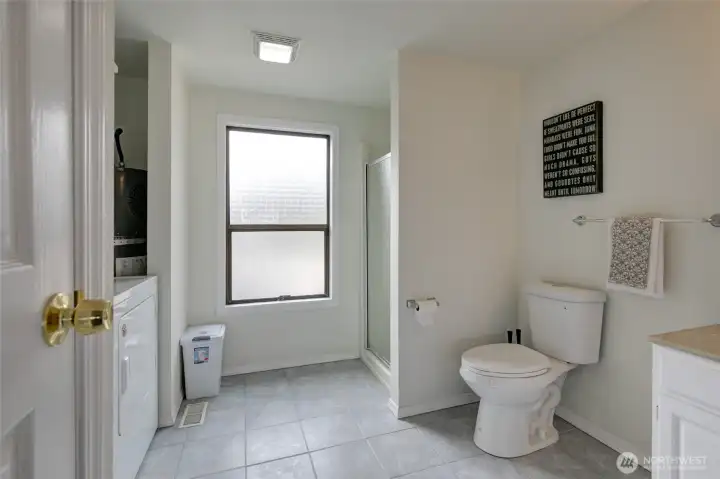 Downstairs bathroom with a walk in shower and washer and dryer.