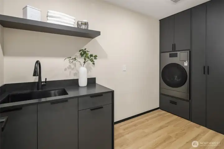 Modern utility – Custom cabinetry and high-performance washer/dryer elevate daily living.