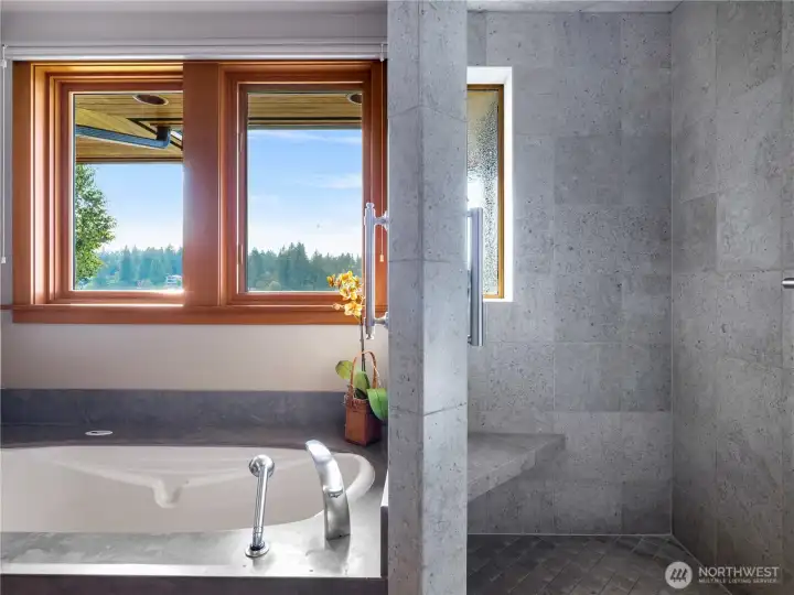 Primary bath with marble surfaces has his and hers vanities.