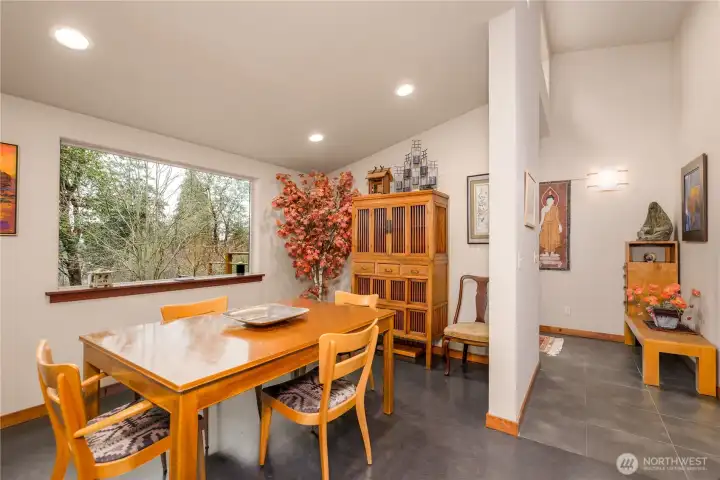 A bright and welcoming dining space where large windows and warm lighting create an inviting setting for gatherings and everyday meals.