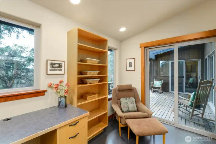 The office features a built-in wraparound workspace and shelving, seamlessly integrated to create a functional and thoughtfully designed work area.