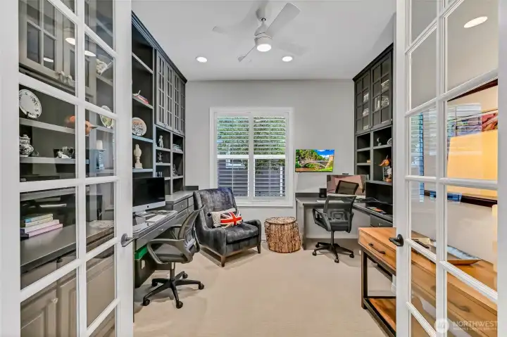 Striking office with dual workstations and floor to ceiling cabinetry.