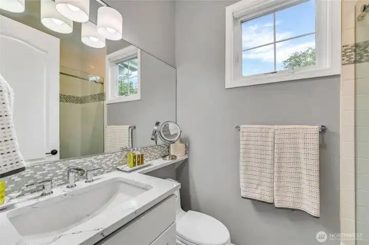 Remodeled guest bath in 2022 with a floor to ceiling tiled shower, custom shower door, Kohler shower head and undermount sink, Toto toiler, bathroom light fixture, and the cabinets were refaced and painted.