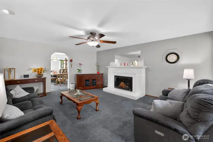 Living room with gas fireplace and ceiling fan