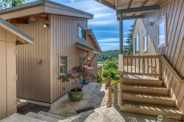 Front patio area of the studio and stairway to lower west landscaped yard. corner of the garage to the left shown here. Stairs to the main house deck that runs along the west side of the house.