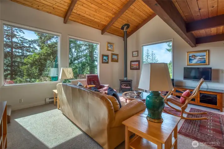 Main house living room. Natural light shines through the large windows throughout all the seasons enjoyed in the northwest.
