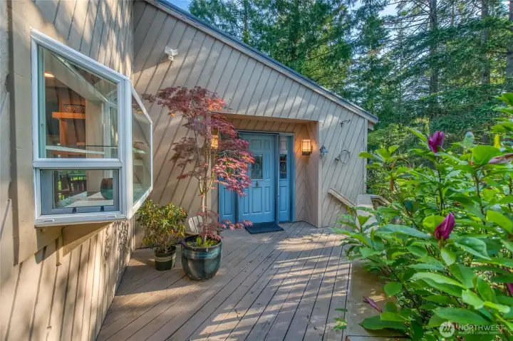 Front deck/door on the main house. Bump-out kitchen window on the left.