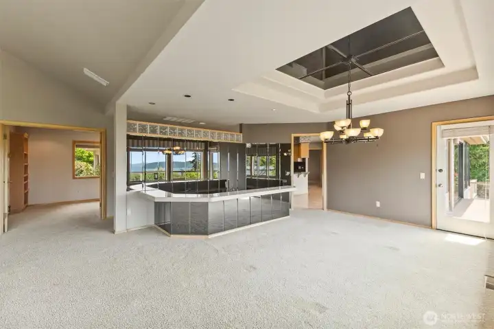 Distinctive sunken wet bar adds character and creates a natural gathering space for entertaining, while mirrored walls reflect the surrounding water and island views throughout the room.