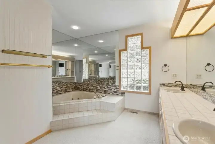The generous primary bath offers dual vanities, a soaking tub, abundant natural light, and plenty of room to create your ideal retreat.