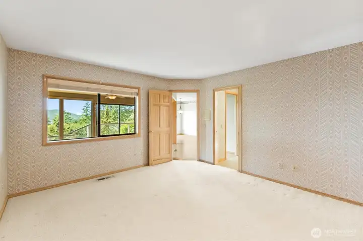 Guest bedroom is adjacent to the family room, where an interior window creates an open feel while allowing natural light and a glimpse of the surrounding scenery to filter through the space.