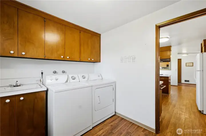 The laundry room is conveniently located adjacent to the kitchen and includes the washer and dryer, storage cabinets, a utility sink and direct access to the backyard and clothesline. The laundry room is conveniently located adjacent to the kitchen and includes the washer and dryer, storage cabinets, a utility sink and direct access to the backyard and clothesline.