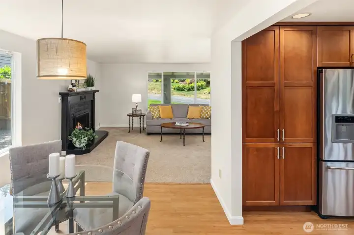 The large, renovated kitchen centers the living space ~ warm wood cabinetry, granite countertops with plenty of prep area, and adjacent dining room.