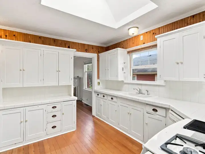 Adorable farmhouse kitchen has a ton of cabinet and counter space.