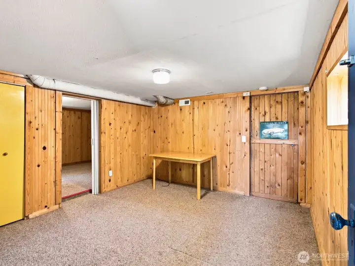 A nice sized rec room greets you. A storage closet is behind the yellow door.