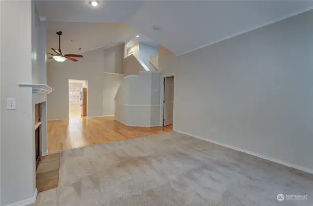 Soaring ceilings in the Great Room Living Space looks back to dining area, and stairs leading to upstairs and skylit flex-space.