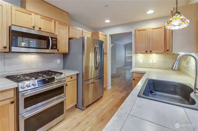 Well appointed kitchen with tile counters, hardwood floors, upgraded appliances and lots of natural light.