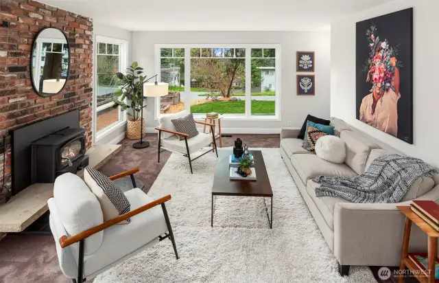 Beautiful living room is light and bright with a wood burning stove. The other entrance is located here (just to the right, out of sight).