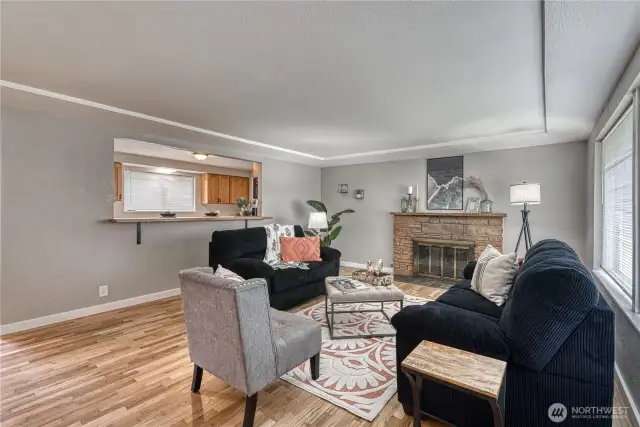 Another living room view featuring the opening to the kitchen with eating bar.