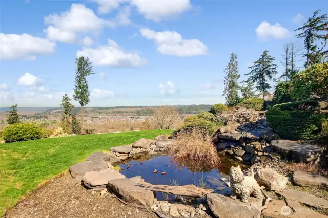 Serene backyard with pond and waterfall. Incredible views of Cascade Mountains, the Orting Valley, Orting's High Cedars Golf Course, and the hawks soaring through the trees.
