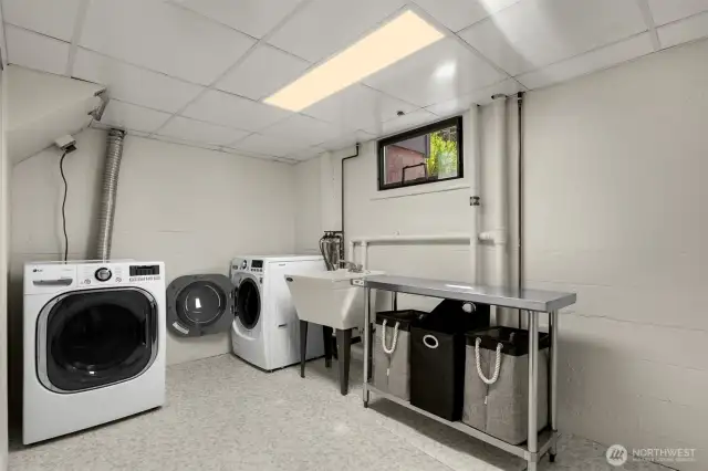 Spacious laundry room with built in shelves to the left of photo.