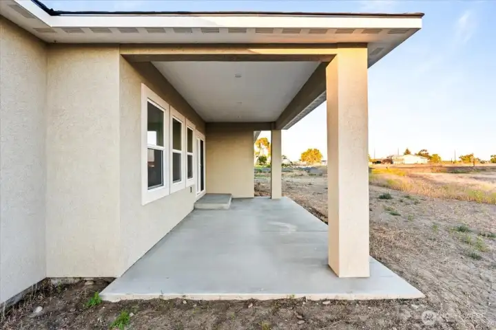 Large covered patio goes out to the new lawn.