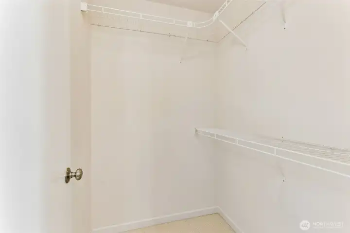 Huge primary walk-in closet with built-in shelving and room for more customization for new owners if desired