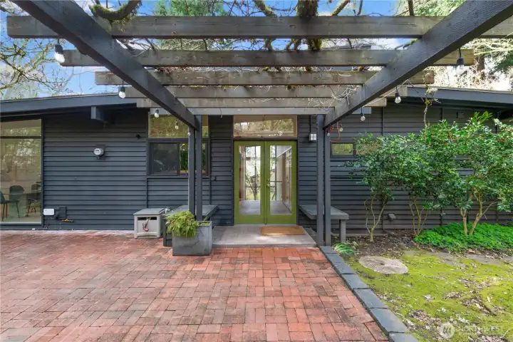 Inviting entry with classic French doors opens into a light-filled interior. Large opposing windows flood the home with natural sunlight, creating a warm and welcoming first impression.