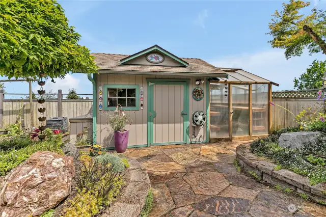 Garden shed with cabinetry, drawers & countertop! Greenhouse on right features filtered water, temperature controlled automatic -opening windows, potting bench, vent fan, grow tables, electrical outlets & sink with running water.