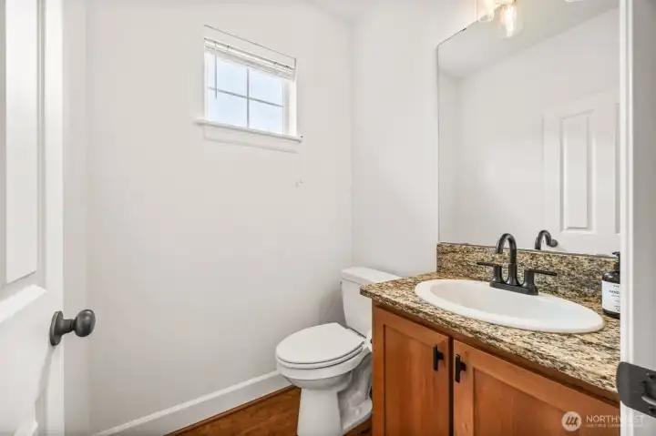 Powder room located on main great room level with new plumbing fixtures including new toilet and lighiting.