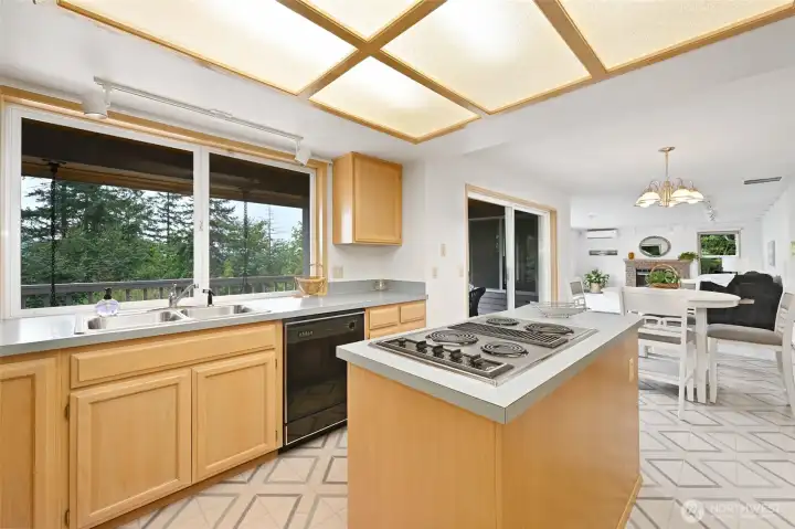 Maple cabinetry and island cooktop, with good storage opens to informal dining area and the family room
