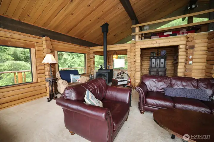 Warm, inviting great room where natural light highlights the craftsmanship of old-growth logs and wood detailing.