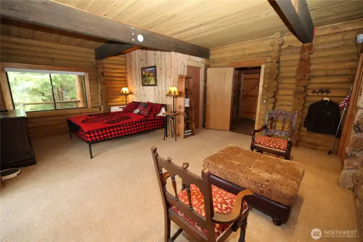 Spacious bedroom with wood accents and natural light, designed for comfort and simplicity