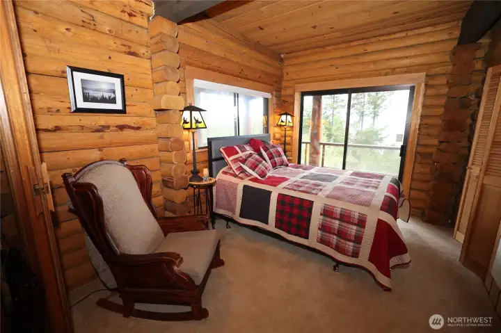 Spacious bedroom with wood accents and natural light, designed for comfort and simplicity.