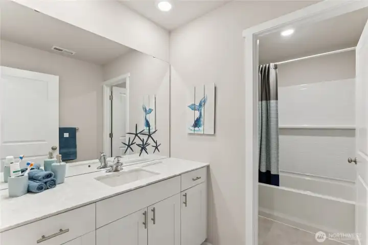 Convenient secondary bathroom with toilet and bathtub private from mirror and sink space. Pictures are for representation only as colors and options will vary. Upper hall bath.