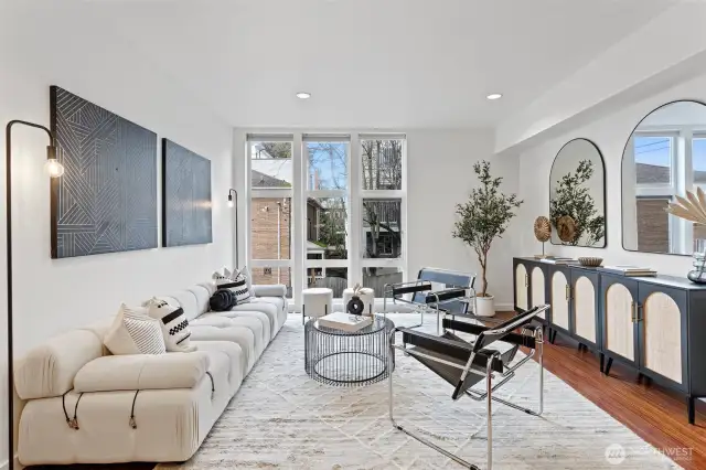 Large floor-to-ceiling windows and high ceilings bring in lots of light to this spacious living area.