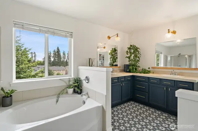 Primary bath has updated lighting, and mirrors. You'll love a long soak in the oversized tub!