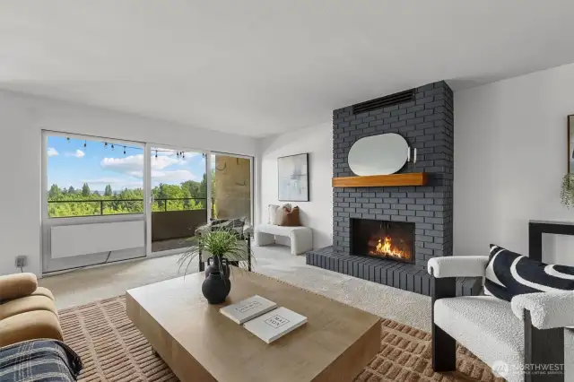 Grounded by a charcoal brick hearth and framed by greenery, the living room offers a calm, elevated space to unwind indoors or out. The glow of the fireplace adds just the right touch of comfort.