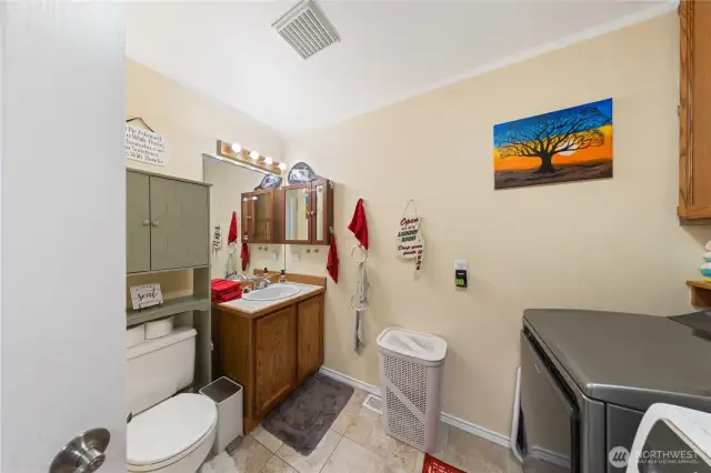 This guest bathroom is located on the main level left side as you enter the foyer and go straight into the kitchen area.   It serves as the utility room and guest bathroom.