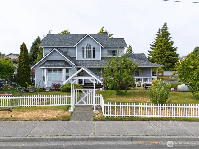 Darling gated entry with matching fencing and front porch.