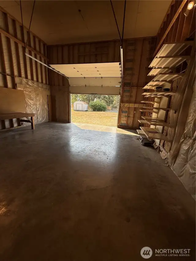 Huge garage with rollup door and high ceiling that could be floored and provide other uses.
