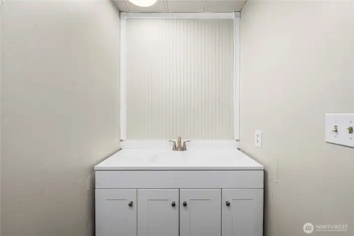 Convenient primary half bath features a new vanity and toilet, ideal for everyday use.