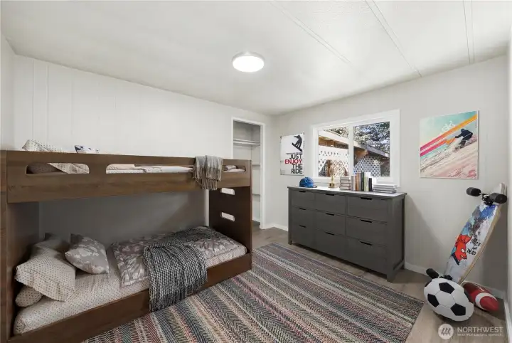 Spacious bedroom offers a comfortable setting with luxury vinyl plank flooring, updated LED lighting, and a new double-paned vinyl window that brings in natural light.  (photo virtually staged)