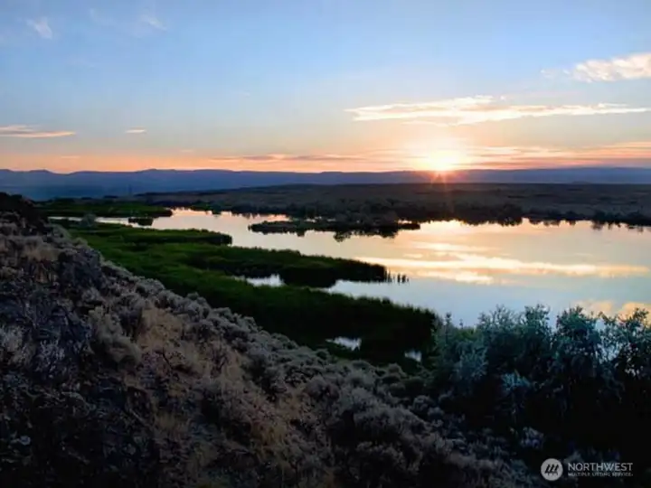 Beautiful vistas.  Sun setting in the West.  Mountain ridges ideal for home-sites. Additional sites around the lake provide dramatic vistas for additional home-sites.  Hilltop Lake below with island in middle.