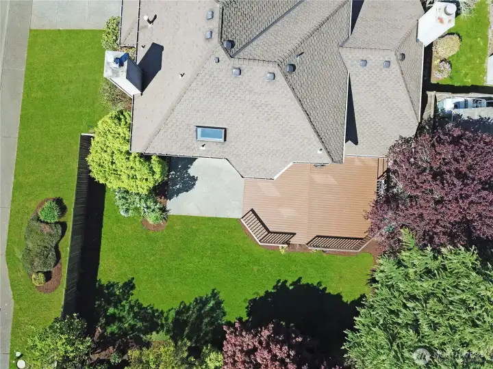 Spacious outdoor area features well-maintained landscaping and large deck of Trex decking for easy upkeep.